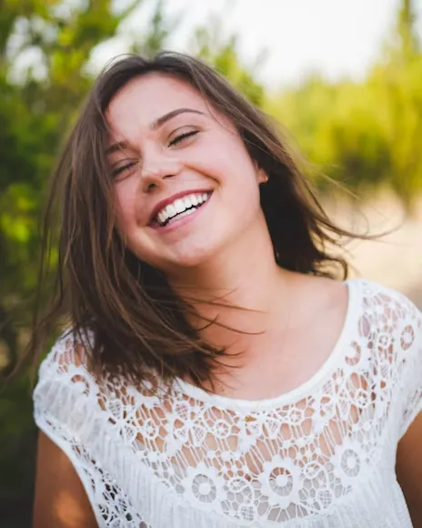 woman in white shirt smiling widely