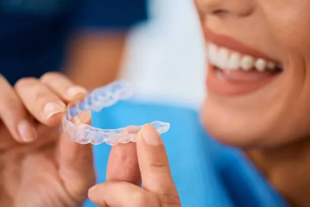 close up of woman getting orthodontic teeth aligner during appointment